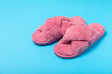 Soft slippers on a bright colored background, close-up. House slippers. Comfortable shoes for home. Foot care concept. Home comfort. Space for text. Copy space.