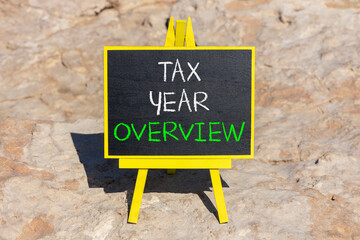 Tax year overview symbol. Concept words Tax year overview on beautiful black yellow blackboard. Beautiful stone background. Business tax year overview concept. Copy space.