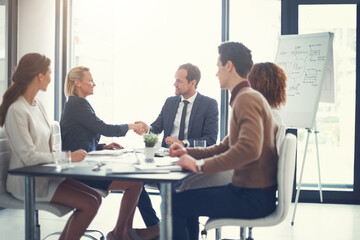 Meeting, handshake and group of business people at presentation for b2b negotiation planning. Workshop, collaboration and team shaking hands in office for deal ideas, agreement and congratulations