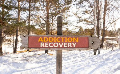 Addiction recovery symbol. Concept words Addiction recovery on beautiful wooden road sign. Beautiful snow forest background. Psychology addiction recovery concept. Copy space.