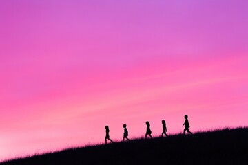 silhouettes of children walking on a hill at sunset