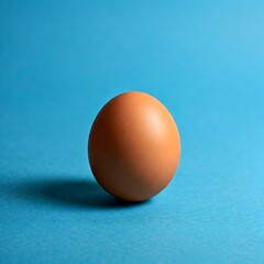 Brown egg on vibrant blue background healthy food concept for kitchen and culinary themes