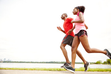 Running, athlete and exercise for couple, fitness and practice for competition with partner, race or outdoor. Workout, cardio and marathon for people with speed, road or runners with energy for sport