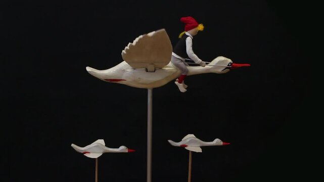 boy nils flies astride a goose, wooden puppets
