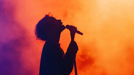 silhouette of a singer performing on stage with orange and purple lights