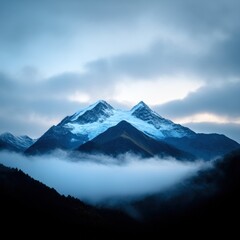 misty blue mountain range with snow capped peaks