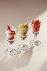 Medicine tablets in a shot glasses like a glass with pieces of fruit. Selective focus. Concepts of medicine tablets and alcohol, fight against alcohol and drug addiction. 