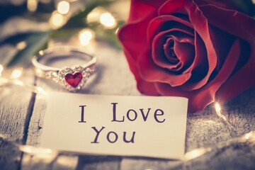 Fototapeta premium Romantic Setting with Heart Ring, Rose, and Love Note on Table