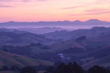 Obraz premium Serene Dawn Over Rolling Hills with Purple Hues and Misty Background