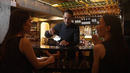 Asian smart bartender mixed vodka cocktail glass decorated flower on top serving to beautiful customer at luxurious counter bar making special drink. Refreshment alcohol nightlife luxury. Vinosity.