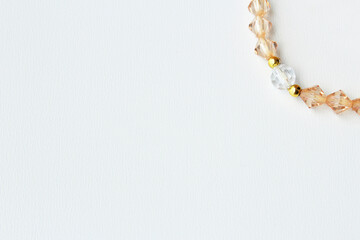 Clean and minimalist banner background with copy space and elegant bead strand in ambar color on right top corner. Ideal for delicate high end costume jewelry design.