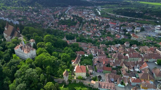 Aerial view of historic centre of Sighisoara, Romania. It is a popular tourist destination for its well-preserved old town, which is listed by UNESCO as a World Heritage Site. Drone going forward.