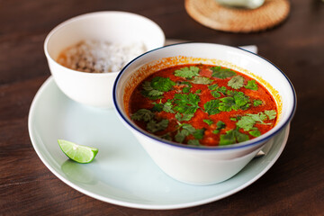 Tom Yum – Spicy Thai soup with shrimp, squid, tomatoes, mushrooms, and herbs, served with steamed rice. Rich in coconut milk, lime, and chili fo