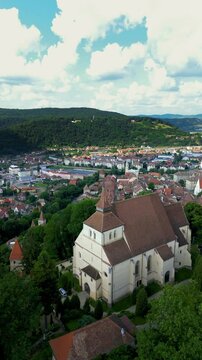 Historic centre of Sighisoara, Romania, aerial view. It is a popular tourist destination for its well-preserved old town, which is listed by UNESCO as a World Heritage Site. Drone circling. Vertical