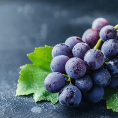 Close-up of fresh, ripe blue grapes with water droplets on a dark background.