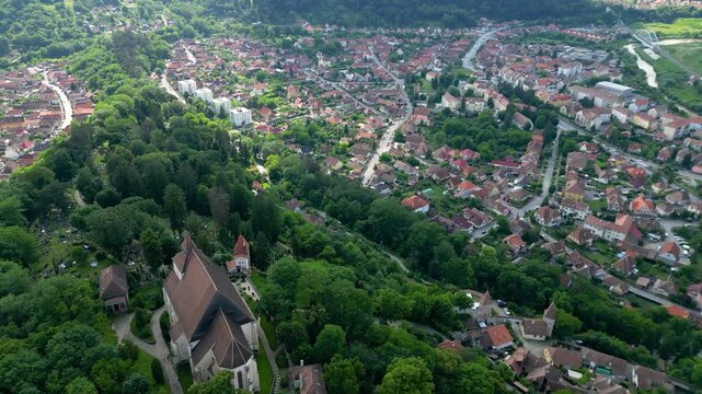 Sighishoara city Romania. Aerial drone perspective of historic city center. Famous travel destination, UNESCO, World Heritage Site. Drone going backwards above the citadel of the city. Green landscape