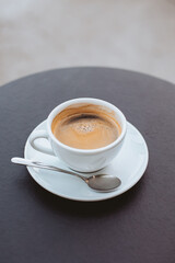 Fototapeta premium Cup of black coffee on a table in a street cafe.