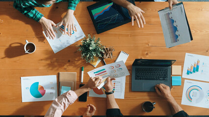 Top down view of smart business people hand working together to analyze chart. Skilled marketing team discussing about financial plan at table with stock market exchange report placed. Convocation.