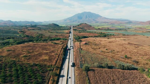 Heavy cargo trucks transporting goods by road near Sanganguey volcano in Tepic, Nayarit, Mexico