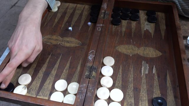 Cairo, Egypt Players at a backgammon board with black and white pieces and dice. 