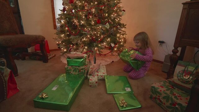 Little Girl Opening Christmas Presents Under the Christmas Tree