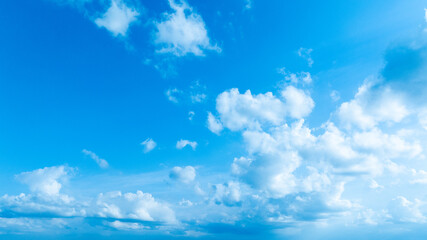 A crisp and clean blue sky featuring scattered soft clouds, ideal for nature and outdoor-themed designs.