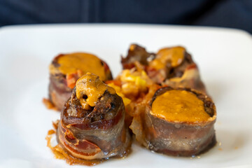 Pork legs stuffed with mushrooms and ham on white plate