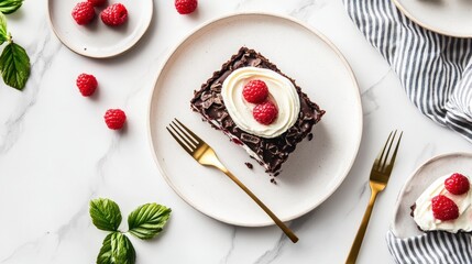 Chocolate tart slice with raspberries and cream on white marble.