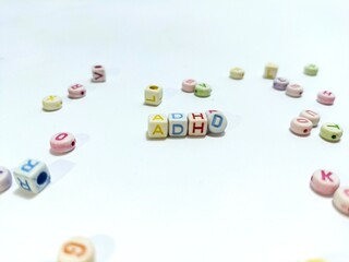 ADHD in alphabet beads on white background.