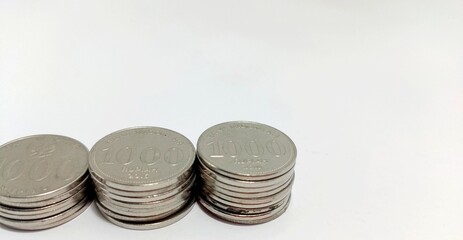 Indonesian coins stacked on a white background, elevated view