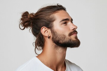 Obraz premium Studio portrait of a handsome young man with trendy hairstyle and earring, looking up with a calm expression