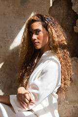 Portrait of a beautiful latin woman with curly blonde hair under natural light