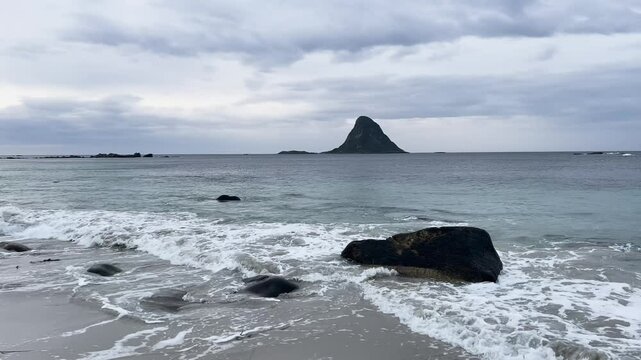White sand beach with turquoise ocean water and a mountain in Bleik beach, Lofoten islands, Norway