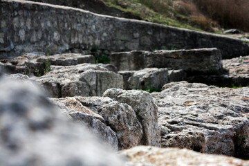 Ancient stones close-up with blurred background. Zoomed-in view of ancient stones of old city.
