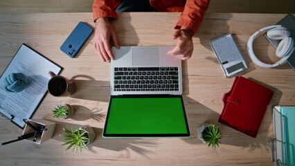 Online manager working mockup laptop at remote workspace top view. Man hands