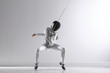 Fencer with epee practicing indoors. Combat sport