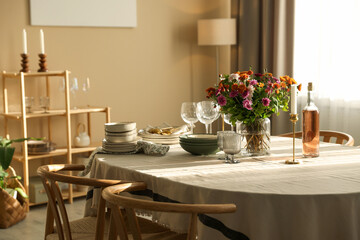 Stylish table setting with dishware, glasses and beautiful flowers indoors