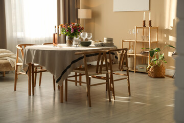 Stylish table setting with dishware, glasses and beautiful flowers indoors