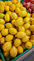Sale of lemons in a supermarket. Citrus fruits in plastic boxes, close-up. Lemons in a store. Ripe, juicy, bright yellow lemons. A pile of lemons for sale at the market