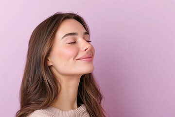Smiling young woman with long wavy brown hair, glowing skin, eyes closed, minimalist pink background, natural beauty portrait, trendy modern hairstyle, serene and relaxed aesthetic

