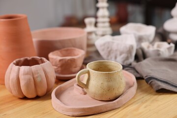 Hobby and craft. Different beautiful pottery on wooden table indoors, closeup