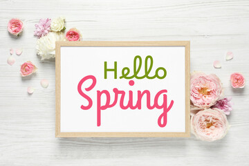 Hello Spring card in frame and beautiful flowers on white wooden background, flat lay