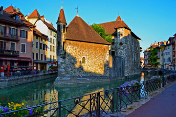 Fototapeta premium Annecy is an old city in eastern France. Reflections of colored houses in the river and flowers along the embankment.