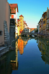 Fototapeta premium Annecy is an old city in eastern France. Reflections of colored houses in the river and flowers along the embankment.