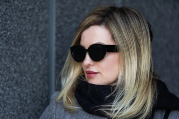 Naklejka premium A young girl blonde walks through the city