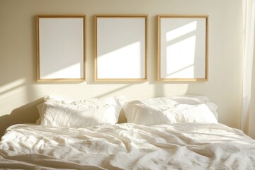 Soft sunlight fills a serene bedroom with white bedding and empty frames on the wall