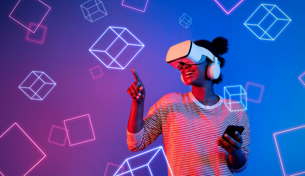 Fototapeta African girl with VR glasses standing at blue and pink background and looking at floating geometric shape. Excited person searching and entering visual reality world. Technology innovation. Ingenuity.