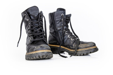 Pair of rugged worn black ankle leather combat boots with  thick, sturdy soles and laces. Two vintage military style shoes. Studio light. Isolated on white background. Empty copy space. Clipping path