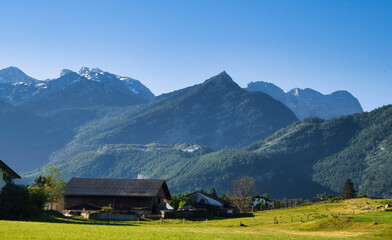 Sun shining on mountains behind houses in Golling an der Salzach, Austria on a spring morning. © Kari