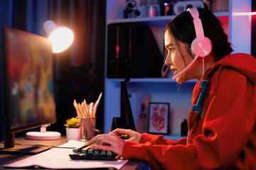 Host channel of young beautiful Asian gaming streamer playing fighting Moba at battle arena game on pc screen with multiplays, wearing pastel headphone at neon digital light modern room. Stratagem. © InfiniteFlow